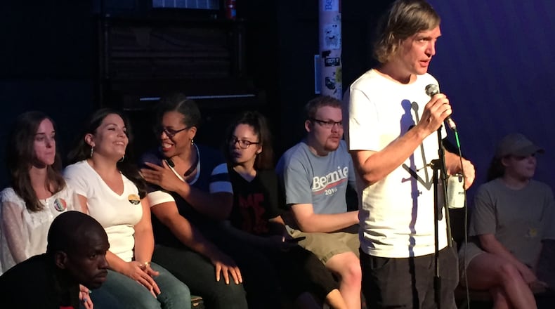 Tim Franzen instructs Bernie Sanders' supporters to tell convention delegates seated behind him what they should try and accomplish this month at the Democratic National Convention. AARON GOULD SHEININ / asheinin@ajc.com