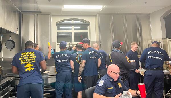 Squad 4 firefighters jostle for position as they all try to help clean the firehouse kitchen. 