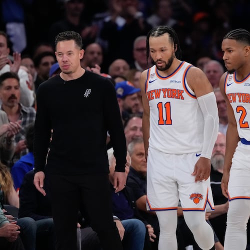 New York Knicks guard Jalen Brunson (11) and guard Miles McBride (2) walk to their bench as San Antonio Spurs head coach Mitch Johnson, left, looks away during second half of Game 3 of the NBA Finals basketball series, Monday, June 8, 2026, in New York. (AP Photo/Ross D. Franklin)