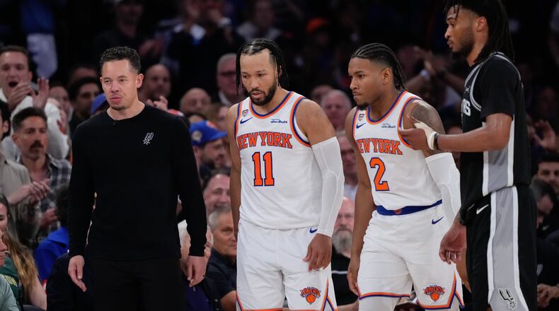 New York Knicks guard Jalen Brunson (11) and guard Miles McBride (2) walk to their bench as San Antonio Spurs head coach Mitch Johnson, left, looks away during second half of Game 3 of the NBA Finals basketball series, Monday, June 8, 2026, in New York. (AP Photo/Ross D. Franklin)