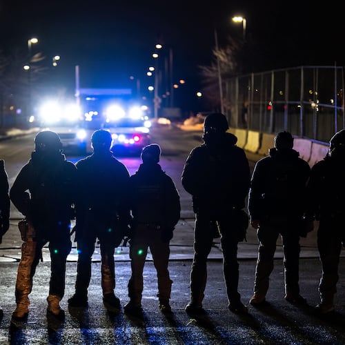 FILE - Federal officers stand guard after detaining people outside of Bishop Henry Whipple Federal Building, Jan. 13, 2026, in Minneapolis. (AP Photo/Adam Gray, File)