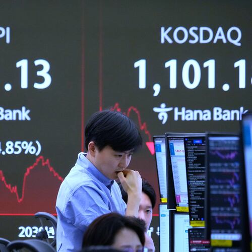 A currency traders watches monitors near a screen showing the Korea Composite Stock Price Index (KOSPI), left, at the foreign exchange dealing room of the Hana Bank headquarters in Seoul, South Korea, Monday, Feb. 2, 2026. (AP Photo/Ahn Young-joon)