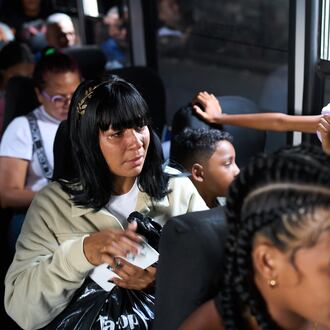 Mileidy Mendoza and her children ride a bus from Caracas to visit her husband, Eric Diaz, imprisoned on political grounds at the Yare prison complex in San Francisco de Yare, Venezuela, Sunday, April 5, 2026. (AP Photo/Ariana Cubillos)