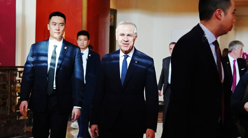 Canada's Prime Minister Mark Carney, center, walks through a hotel lobby in Beijing, China Thursday, Jan. 15, 2026. (Sean Kilpatrick/The Canadian Press via AP)