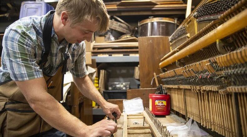 Nate Otto repairs player pianos in the workshop of his Anoka home. He cleaned front rail pins on a piano he is fixing up to replace his own. (Alex Kormann/Star Tribune/TNS)