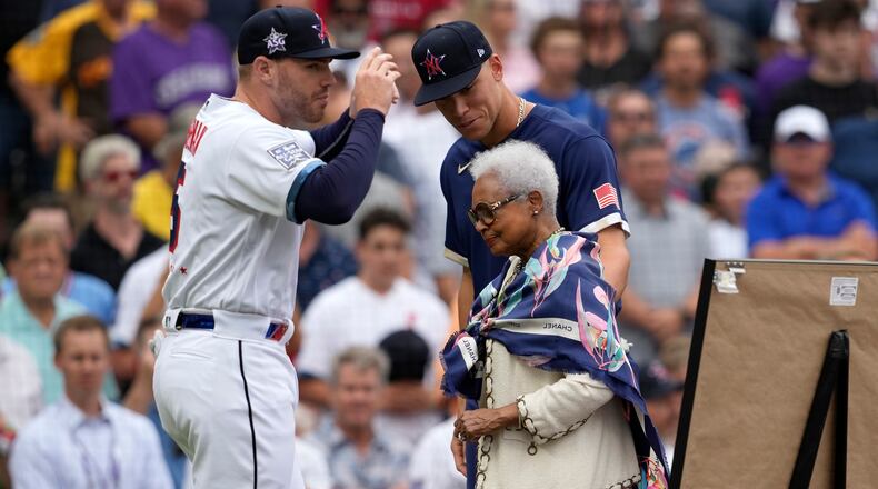 National League's Freddie Freeman, of the Atlanta Braves, left, and American League's Aaron Judge, of the New York Yankees, right, escort the wife of the late Hank Aaron, Billye Aaron, onto the field prior to the MLB All-Star baseball game, Tuesday, July 13, 2021, in Denver. (AP Photo/David Zalubowski)