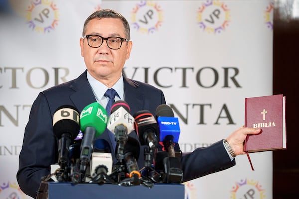 Presidential candidate Victor Ponta holds a bible during a press conference in Bucharest, Romania, Friday, May 2, 2025. (AP Photo/Andreea Alexandru)