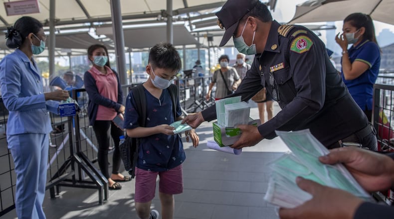 Health officials distribute protective face masks for visitors at a luxury mall in Bangkok, Thailand, Tuesday, Jan. 28, 2020. Panic and pollution drive the market for protective face masks, so business is booming in Asia, where fear of the new coronavirus from China is straining supplies and helping make mask-wearing the new normal. (AP Photo / Gemunu Amarasinghe)