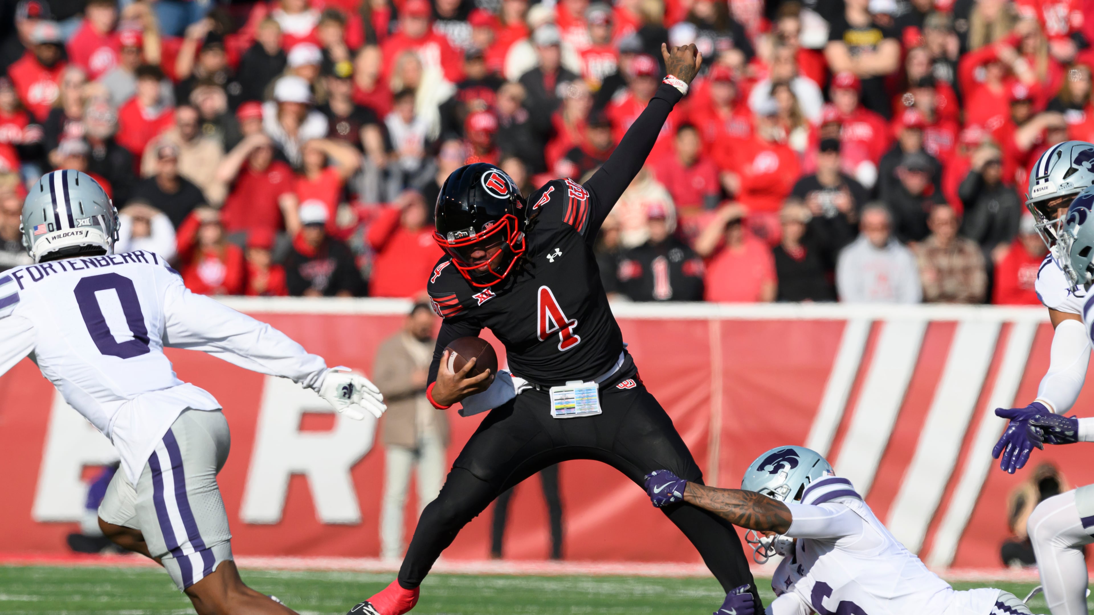 Utah quarterback Devon Dampier (4) is tackled by Kansas State defensive back Qua Moss, bottom right, during the first half of an NCAA college football game, Saturday, Nov. 22, 2025, in Salt Lake City. (AP Photo/Tyler Tate)