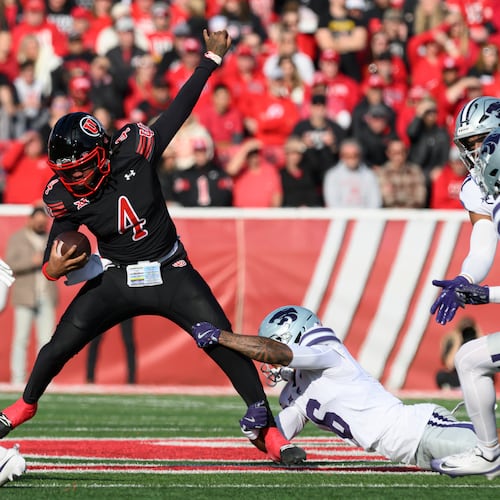 Utah quarterback Devon Dampier (4) is tackled by Kansas State defensive back Qua Moss, bottom right, during the first half of an NCAA college football game, Saturday, Nov. 22, 2025, in Salt Lake City. (AP Photo/Tyler Tate)
