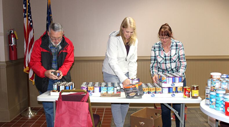 On food pantry pick-up day (from left), Kendall Jones of MUST Ministries, Elissa Wallace with Papa’s Pantry and Millie Hughes of Never Alone divide items donated in the 2018 Leadership Cherokee Leading by Feeding initiative. This year’s campaign is underway and runs through October. CHEROKEE COUNTY CHAMBER OF COMMERCE