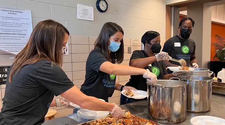 Marin Kraushaar and other Georgia's Own Credit Union volunteers prepare to serve hot meals on Thursday.