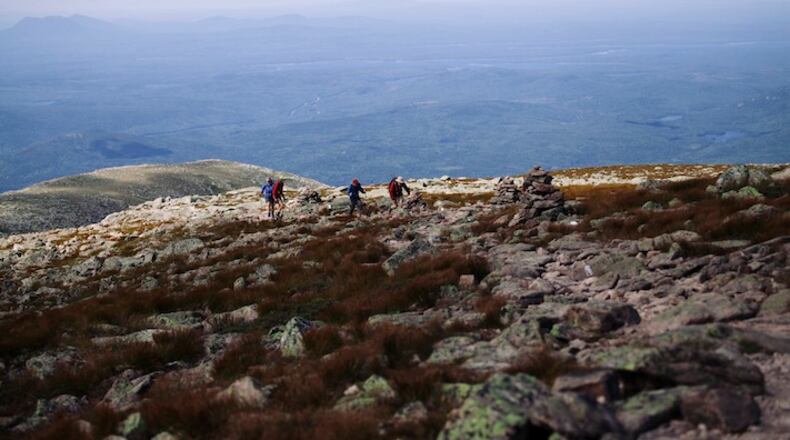 FILE — A group of hikers summit Mount Katahdin, the northern terminus of the Appalachian Trail, at Baxter State Park in Maine, Aug. 14, 2015. Long-distance endurance hiking is one athletic endeavor where elite women seem to be at little or no disadvantage to men. From left: Lori Barkley, 43, of Portland, Ore., William Young, 69, of Hanover, N.H., Tom Buononato, 22, of Wayne, N.J. and Tom Kidder, 67, of West Newbury, Vt., (Tristan Spinski/The New York Times)
