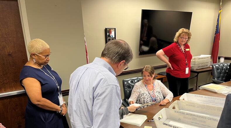 Cityhood supporter Jimmy Eastham (center) and Cobb Elections Director Janine Eveler (right) look on as election workers conduct a partial recount of the Vinings cityhood election Monday, June 6, 2022 in Marietta.