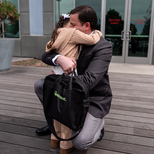 FILE - Milenko Faria, whose wife, Dr. Rubeliz Bolivar, is in immigration custody, hugs their daughter, Milena, after his asylum interview at the U.S. Citizenship and Immigration Services facility in Tustin, Calif., Thursday, April 16, 2026. (AP Photo/Jae C. Hong, File)