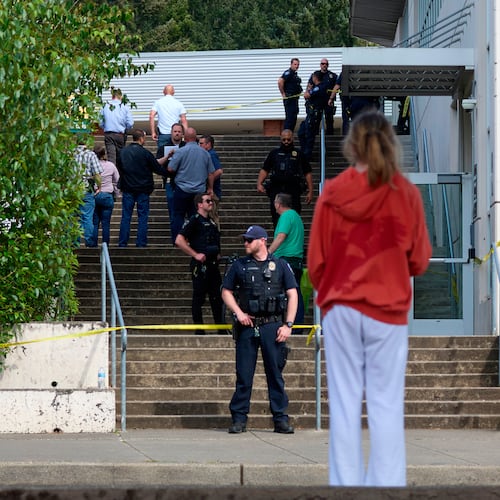 A student watches as Tacoma Police officers investigate after multiple people were injured in a stabbing at Foss High School, Thursday, April 30, 2026, in Tacoma, Wash. (AP Photo/John Froschauer)