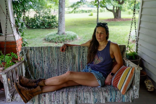 Lori Breedlove is photographed on the porch of the family's 1911 farmhouse, a multigenerational farm outside Watkinsville in Oconee County. A proposed highway bypass would cut through the property. (Miguel Martinez/AJC)
