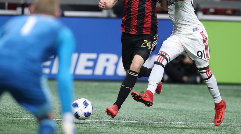 Atlanta United midfielder Julian Gressel battles D.C. United Oniel Fisher as he takes a shot on goal in a MLS soccer game on Sunday, March 11, 2018, in Atlanta.    Curtis Compton/ccompton@ajc.com