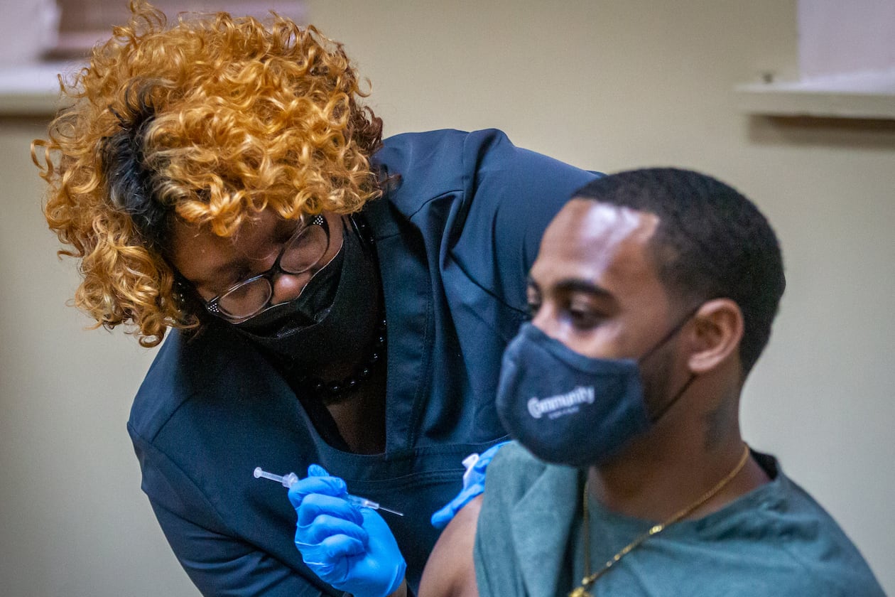 Nurse Nicole McCoy gives James Mays a booster shot at the New Georgia Project vaccination clinic located in the Our Lady of Lourdes Catholic Church last month. (Steve Schaefer for The Atlanta Journal-Constitution)