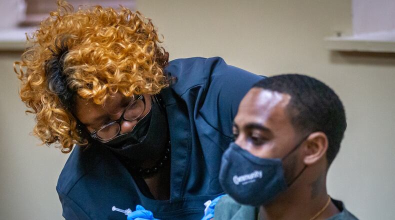 Nurse Nicole McCoy gives James Mays a booster shot at the New Georgia Project vaccination clinic located in the Our Lady of Lourdes Catholic Church last month. (Steve Schaefer for The Atlanta Journal-Constitution)