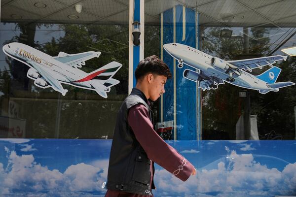 An Afghan man passes in front of an air travel agency in Kabul, Afghanistan, Thursday, June 5, 2025. The Afghanistan travel ban was announced as forms of support for Afghans who worked with the U.S. are being steadily eroded under the Trump administration. (AP Photo/Ebrahim Noroozi)
