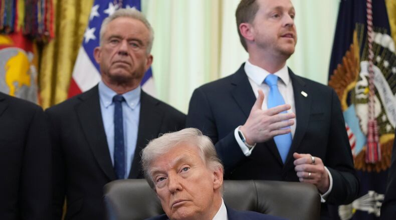 Chris Klomp, director of the Centers for Medicare and Medicaid Services, right, speaks as President Donald Trump and Health and Human Services Secretary Robert F. Kennedy Jr. listen during an event on health care affordability in the Oval Office at the White House, Thursday, April 23, 2026, in Washington. (AP Photo/Mark Schiefelbein)