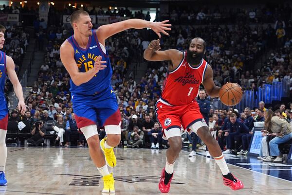 Los Angeles Clippers guard James Harden, right, drives past Denver Nuggets center Nikola Jokic (15) in the second half of Game 1 of an NBA first-round playoff series Saturday, April 19, 2025, in Denver. (AP Photo/David Zalubowski)