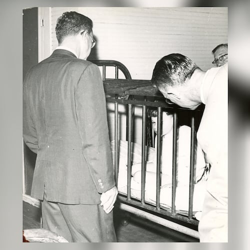 Visitors to Milledgeville State Hospital observe a small boy restrained in a metal cage in the 1940s. The Atlanta Constitution later published a series of stories about conditions at what was then one of the world’s largest mental institutions. (AJC file)