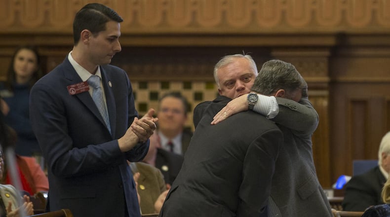 Georgia state Rep. Micah Gravely, right, receives a hug after House Bill 324 gained the approval of the House on Tuesday. The bill would allow medical marijuana oil to be sold to registered patients, giving them a legal way to obtain a drug that they’re already allowed to use. (ALYSSA POINTER/ALYSSA.POINTER@AJC.COM)