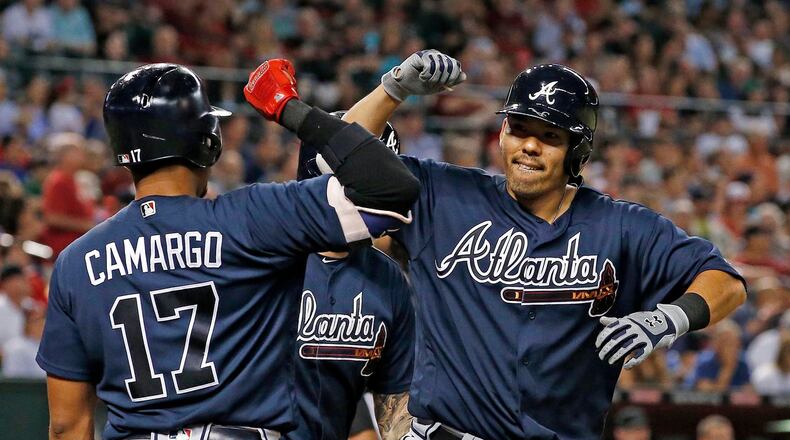 Atlanta Braves' Kurt Suzuki, right, celebrates his two-run home run against the Arizona Diamondbacks with Johan Camargo (17) during the seventh inning of a baseball game Tuesday, July 25, 2017, in Phoenix. The Braves won, 8-3. (AP Photo/Ross D. Franklin)