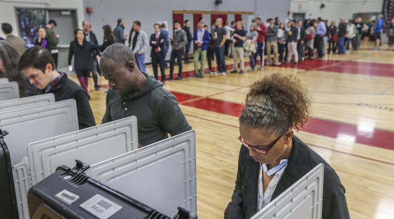 Chandra Brown casts her ballot as voters waited Nov. 8 at Henry W. Grady High School. Voters in majority black precincts strongly supported a charter school amendment in 2012, but they turned their backs on this year’s education issue, the Opportunity School District, which also had a strong charter school element. JOHN SPINK /JSPINK@AJC.COM