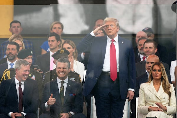 President Donald Trump salutes as attends a military parade commemorating the Army's 250th anniversary, coinciding with his 79th birthday, Saturday, June 14, 2025, in Washington, as Secretary of the Army Daniel Driscoll, Defense Secretary Pete Hegseth, and first lady Melania Trump, watch. (AP Photo/Julia Demaree Nikhinson)