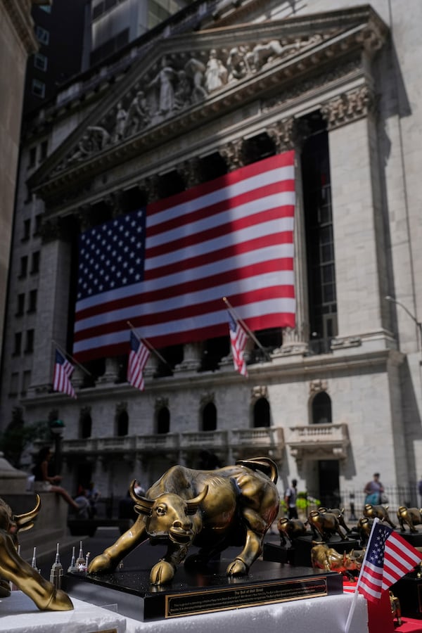 A vendor displays souvenirs on the street in front of the New York Stock Exchange in New York, Monday, July 14, 2025. (AP Photo/Seth Wenig)