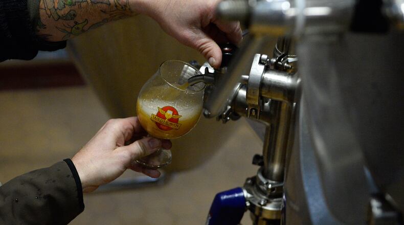 Wild Heaven Brewery co-owners Eric Johnson and Nick Purdy draw a taste of their craft beer from a fermenting barrel at their brewery Monday, Nov. 17, 2014, in Decatur, Ga. David Tulis/AJC Special
