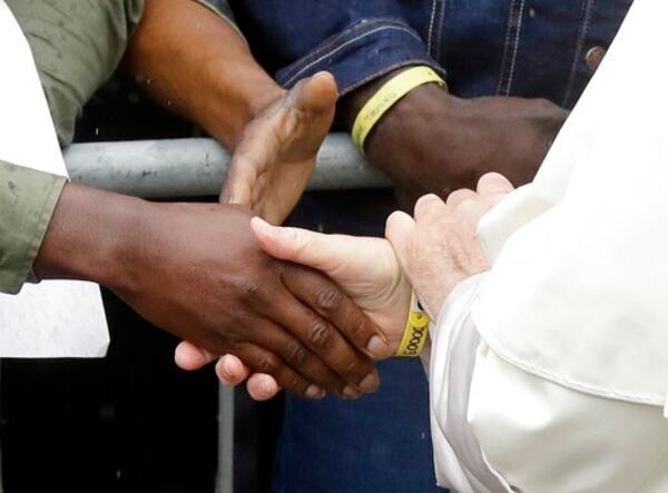FILE - Pope Francis shakes hands with migrants as he arrives at a regional migrant center to meet youths from Africa, in Bologna, Italy, Sunday, Oct. 1, 2017. (AP Photo/Luca Bruno, File)