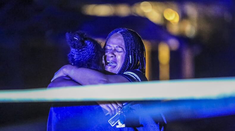 Friends and family members of a man who was shot and killed early Thursday, Feb. 22, 2018, in DeKalb County grieve at the scene. Nicholas Bankston was returning home following his own birthday celebration when he was shot and killed, according to neighbors. His children and two other adults were also in the car, but none were injured. (JOHN SPINK/JSPINK@AJC.COM)