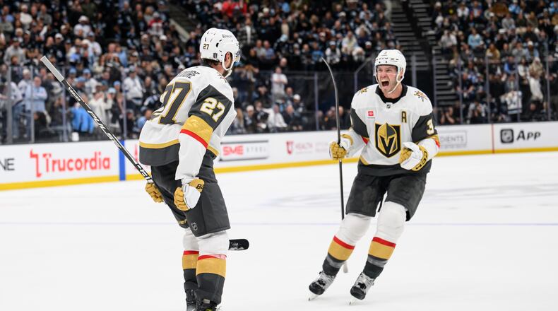 Vegas Golden Knights Brayden McNabb, right, celebrates with Shea Theodore, left, who scored the winning goal during the overtime period of Game 4 of a first-round NHL hockey Stanley Cup playoff series against the Utah Mammoth, Monday, April 27, 2026, in Salt Lake City. (AP Photo/Tyler Tate)