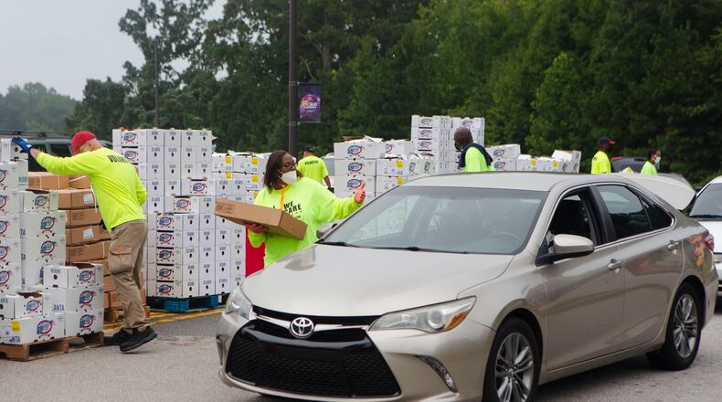 Volunteers load cars with boxes of food during a food giveaway event at Berean Christian Church on Saturday, August 27, 2022, in Stone Mountain. Boxes handed out in DeKalb County included Georgia-grown fruits and vegetables, eggs and 10-pound bags of chicken. CHRISTINA MATACOTTA FOR THE ATLANTA JOURNAL-CONSTITUTION.