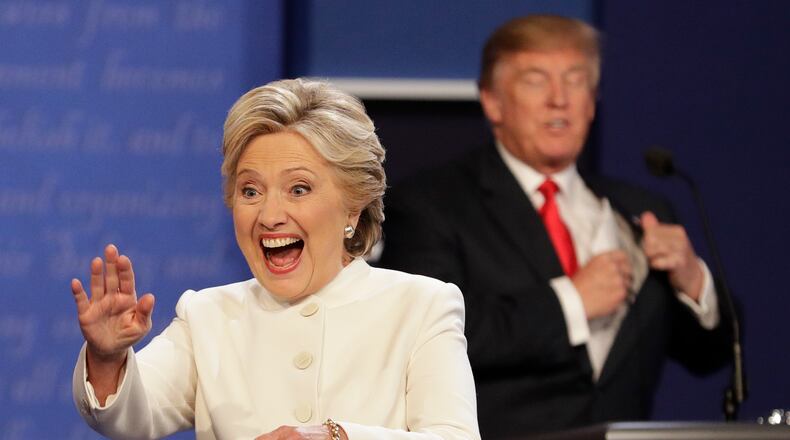 Democratic presidential nominee Hillary Clinton waves to the audience as Republican presidential nominee Donald Trump puts his notes away after the third presidential debate at UNLV in Las Vegas, Wednesday, Oct. 19, 2016. (AP Photo/John Locher)