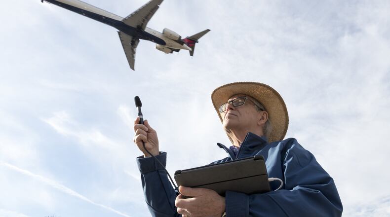 College Park city councilman Ambrose Clay poses measures aircraft noise as a jet passes overhead near Hartsfield-Jackson International. He pushed for a recently approved airport noise referendum calling for Congress to direct the FAA to develop a new noise exposure measure. The referenda also calls for federal funding for new noise insulation to help affected residences. (DAVID BARNES / DAVID.BARNES@AJC.COM)