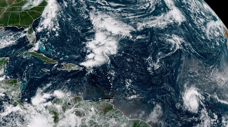 A satellite photo provided by the National Oceanographic and Atmospheric Administration shows Tropical Storm Sam, lower right, on Thursday. Sam is the 18th named storm of a busy 2021 hurricane season, and the fourth to form in less than a week.