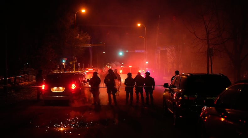 FILE - Tear gas surrounds federal law enforcement officers as they leave a scene after a shooting on Wednesday, Jan. 14, 2026, in Minneapolis. (AP Photo/John Locher, File)