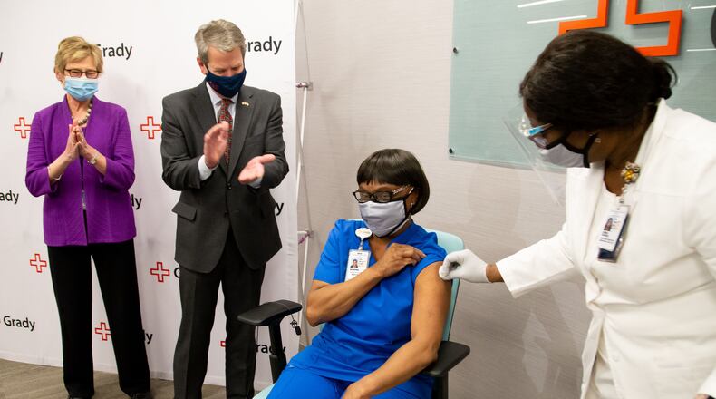 Georgia Gov. Brian P. Kemp and Dr. Kathleen Toomey clap after Grady ICU nurse Norma Poindexter receives her COVID-19 vaccination at Grady Hospital on Thursday, Dec. 17, 2020. (Steve Schaefer/Atlanta Journal-Constitution/TNS)