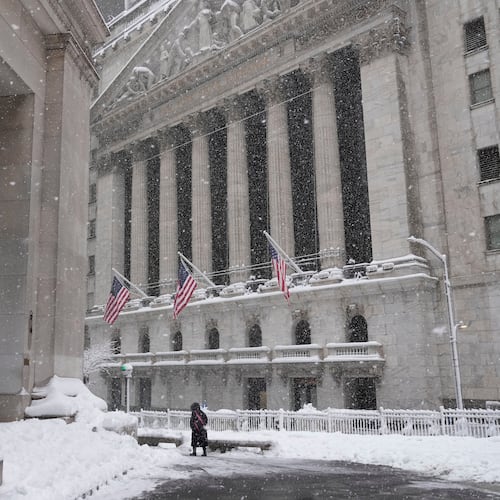 A pedestrian walks outside the New York Stock Exchange during a snow storm, Monday, Feb. 23, 2026, in New York. (AP Photo/Seth Wenig)