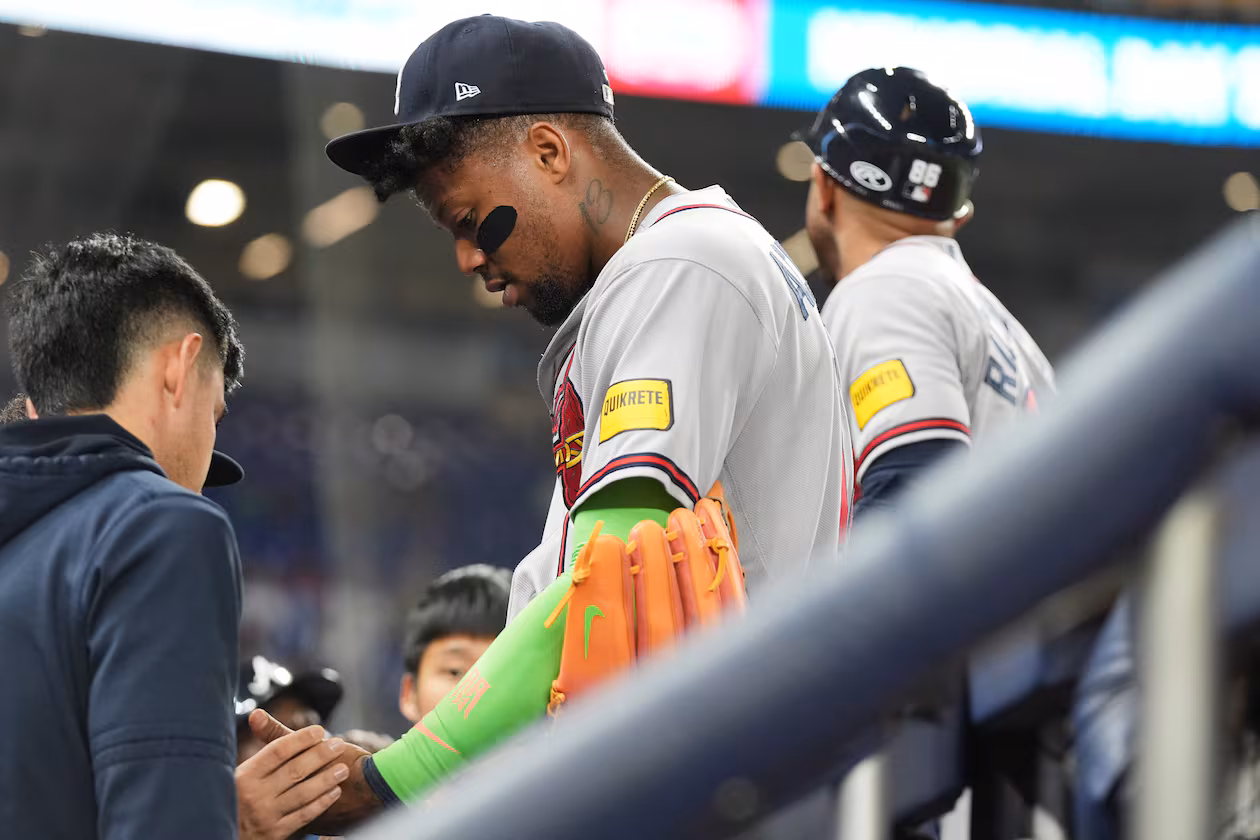 Atlanta Braves' Ronald Acuna, center, has his finger looked at during the fifth inning of a baseball game against the Miami Marlins, Thursday, May 21, 2026, in Miami. (Lynne Sladky/AP)