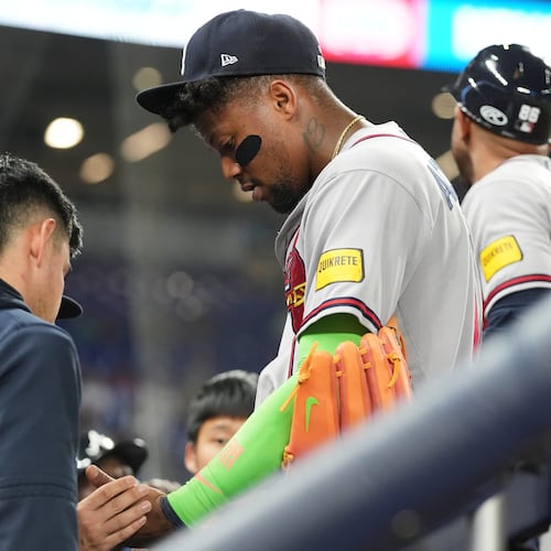 Atlanta Braves' Ronald Acuña Jr. (right) has his finger looked at during the fifth inning of a baseball game against the Miami Marlins, Thursday, May 21, 2026, in Miami. (Lynne Sladky/AP)