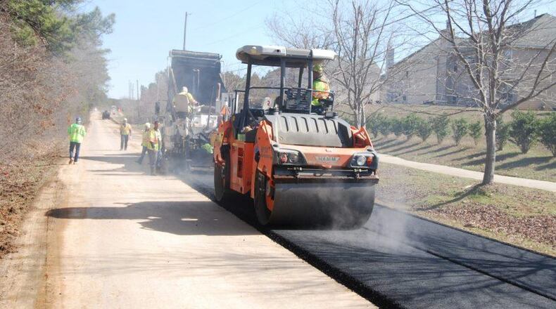 Repair and repaving work like this will be taking place on Arnold Mill Road and Towne Lake Parkway through downtown Woodstock in the coming days. AJC FILE