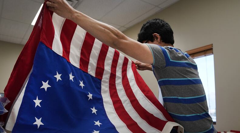 A worker folds a newly made Betsy Ross flag at Colonial Flag on July 5, 2019, in Salt Lake City, Utah. The Betsy Ross flag became a controversy recently when Nike removed shoes with the flag on it from stores after Colin Kaepernick told Nike that the 13-star flag represented oppression and slavery. (Photo by George Frey/Getty Images)