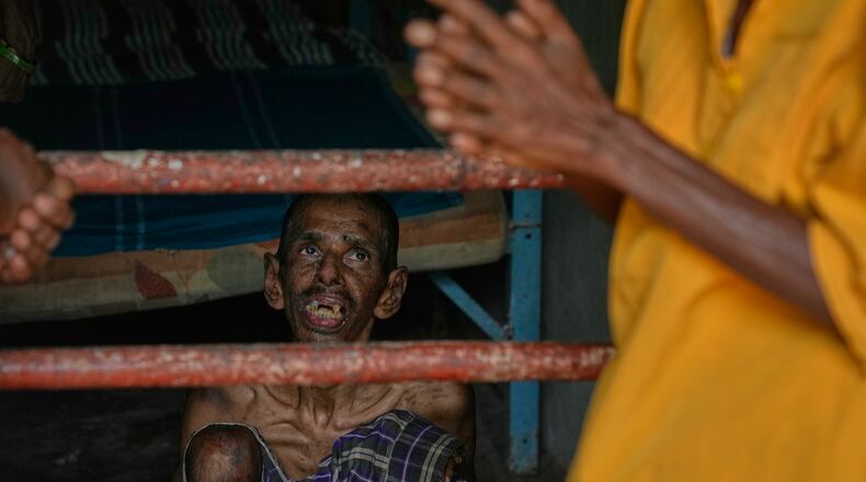 A resident looks at his family members as he sits inside his dormitory at a nursing home in Anguruwatota, Sri Lanka, Friday, June 5, 2026. (AP Photo/Eranga Jayawardena)