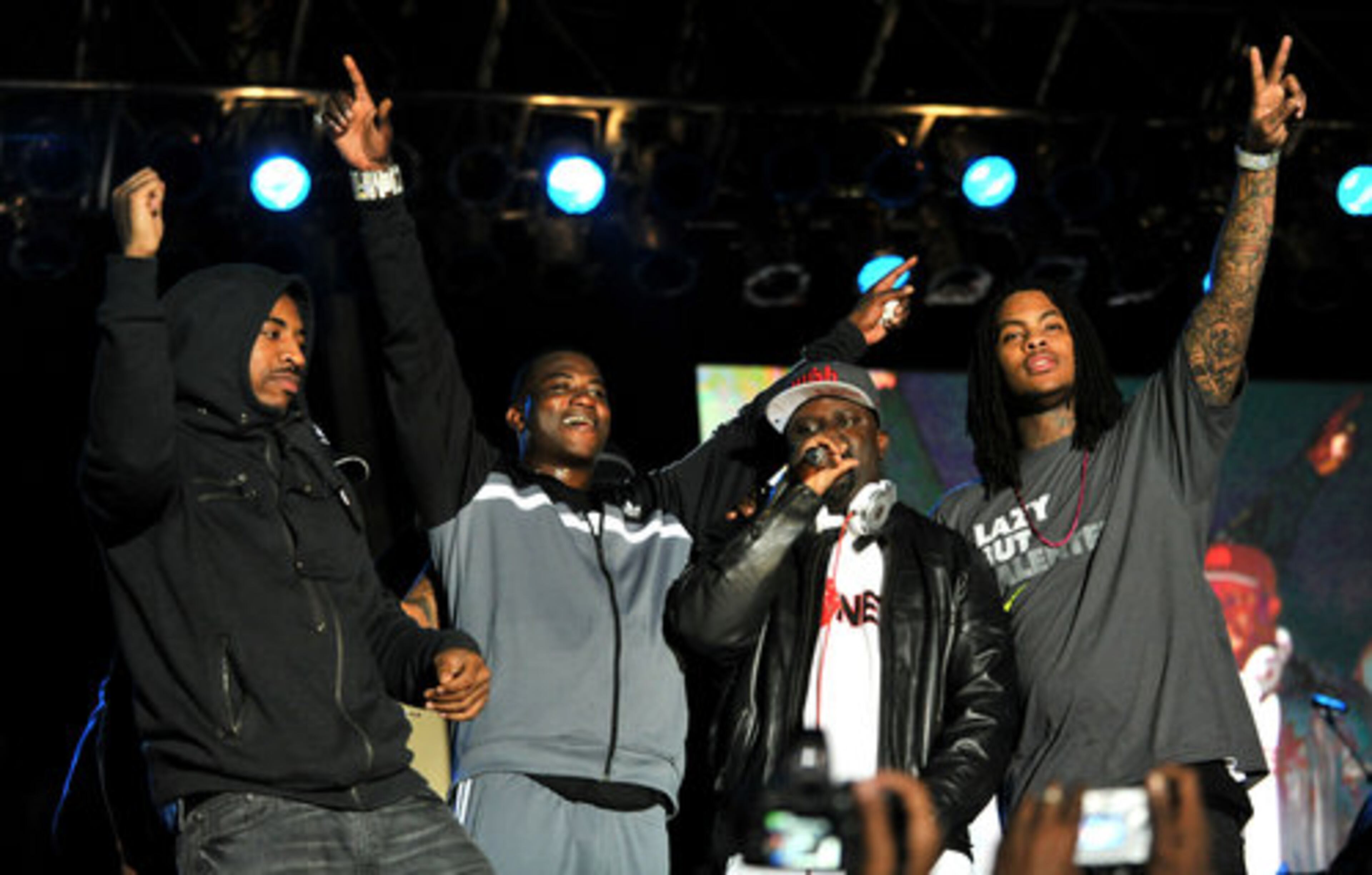 DJ Holiday (from left), Gucci Mane, DJ Greg Street and Wacka Flocka Flame acknowledge the crowd at the fourth annual Thanksgiving Carnival. (Hyosub Shin/AJC)
